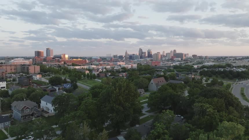 A metropolitan city with a suburban region full of trees and in the background a center with huge buildings