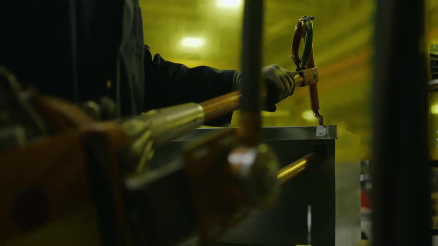 Person using a manufacturing tool in an indoor factory