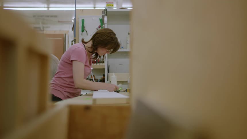 Concentrated woman working with a pen inside a factory