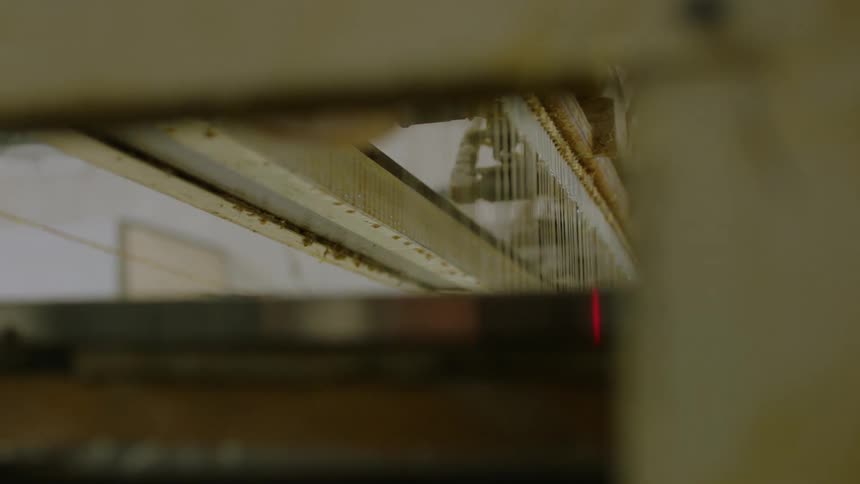 A large mechanized loom moves while stitching