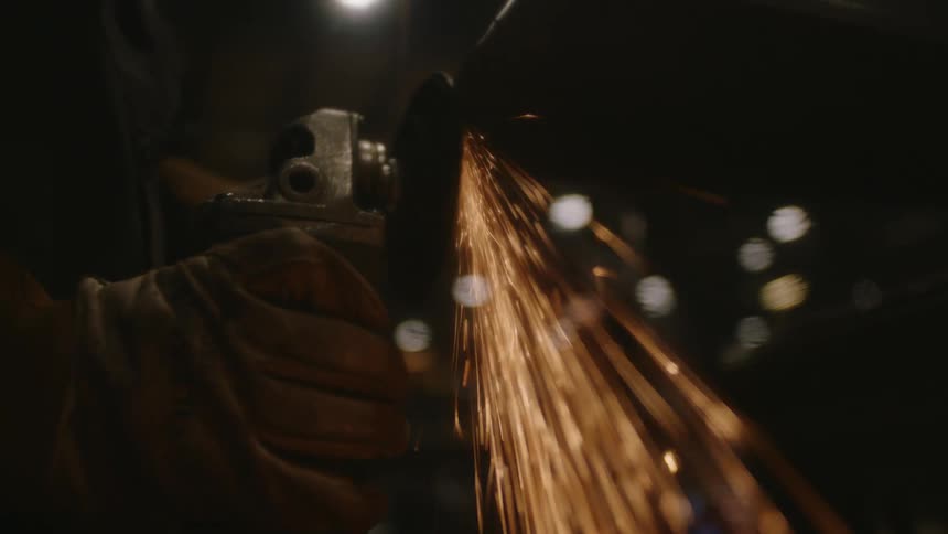 A worker is using an angle grinder