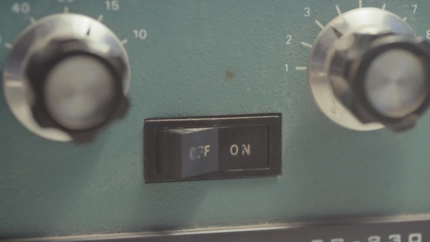 A closeup of a control panel with two knobs and a flip switch labeled off on one side and on