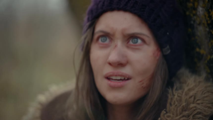 Portrait of a woman with blood marks on her face standing in a forest
