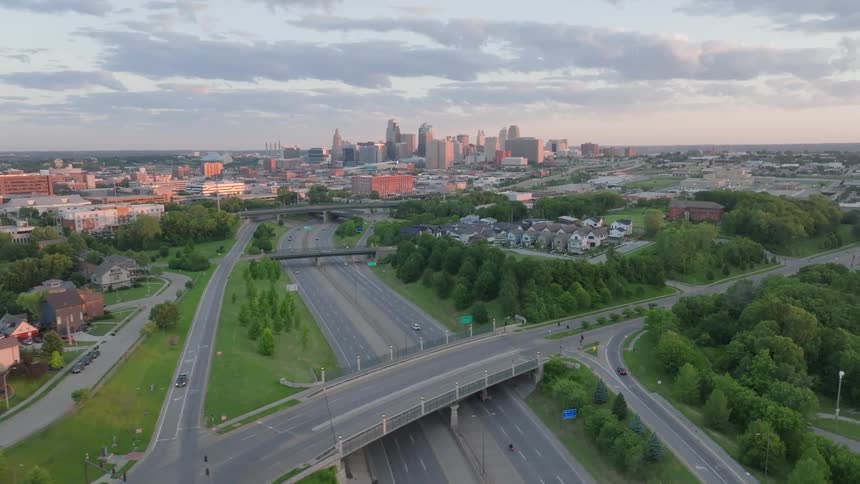 Traffic moves down a highway bisecting a city and suburb
