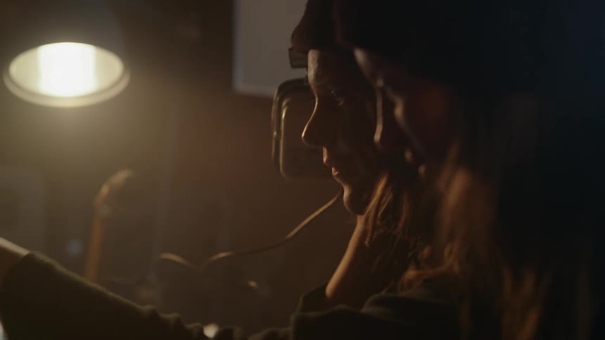 Two young women and men in an indoor space setting up an old control radio