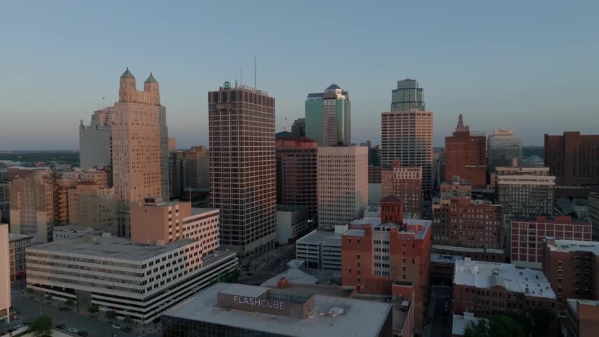 A metropolitan city center with several tall buildings and a clear blue sky