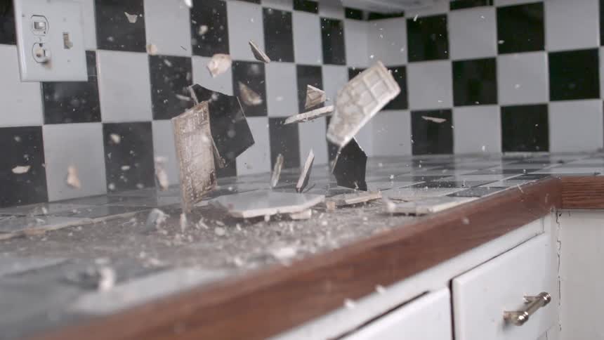 A tile counter is being smashed with a sledgehammer