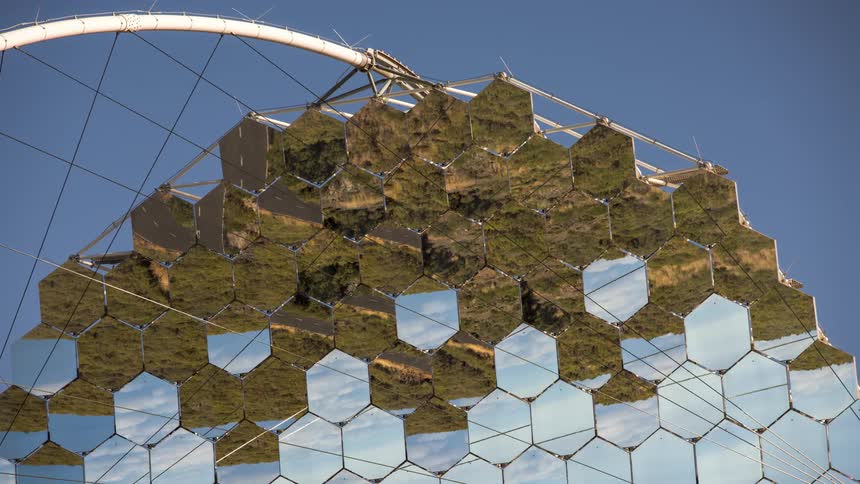 The mirrors of an observation antenna that are reflecting a grass ground