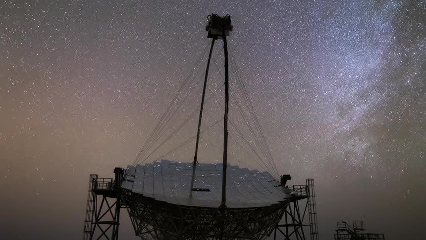 Large telescope with a metal structure under a starry night sky with the milky way in the background