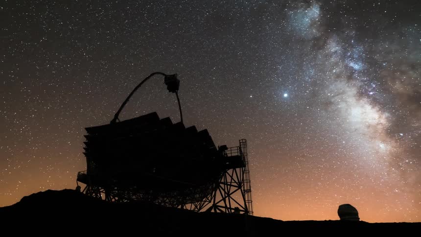 Large telescope with a metal support structure and a reflecting surface under a clear dusk sky