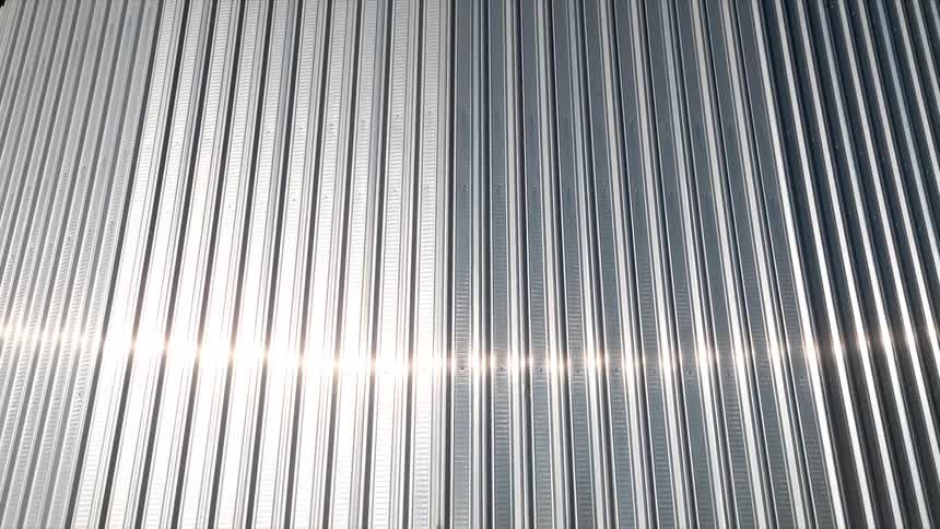 A shiny metal wall with several raised metal stripes