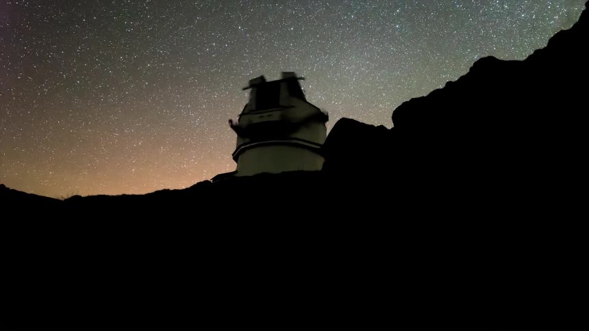 Silhouette of a telescopic observatory against a starry night sky