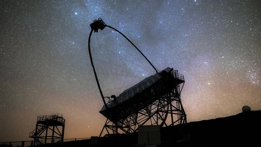 A silhouette of an observation antenna facing the starry sky