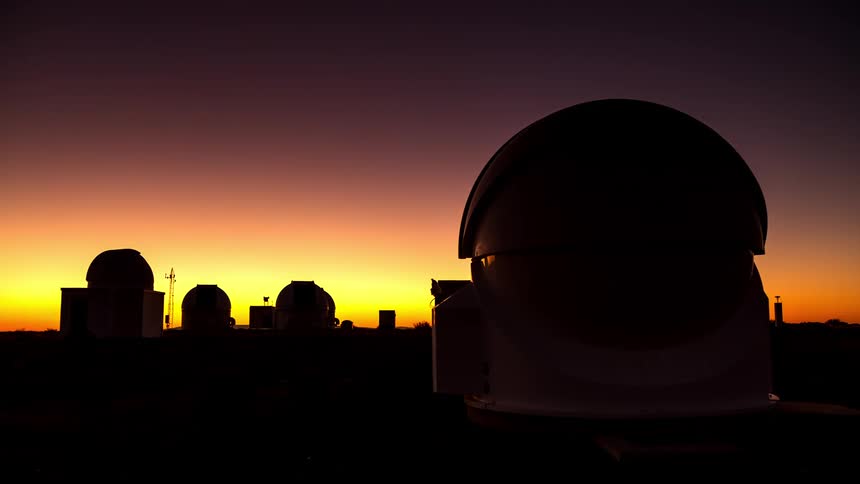 Observatory with several domeshaped structures against a darkening twilight sky