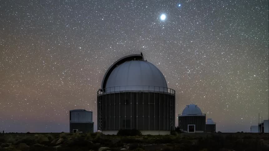 An observatory moving and the sky is dark and full of bright stars