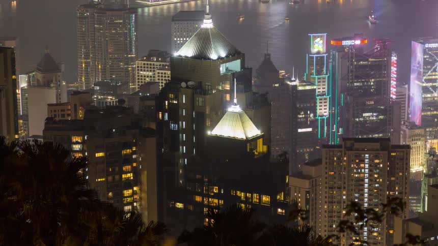 Night view of a city with illuminated skyscrapers by the sea