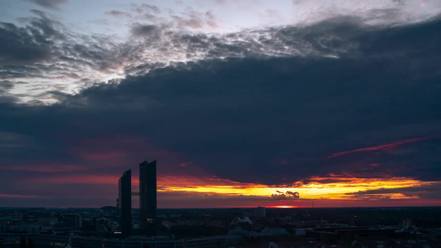 Dark clouds move over a large city at dusk