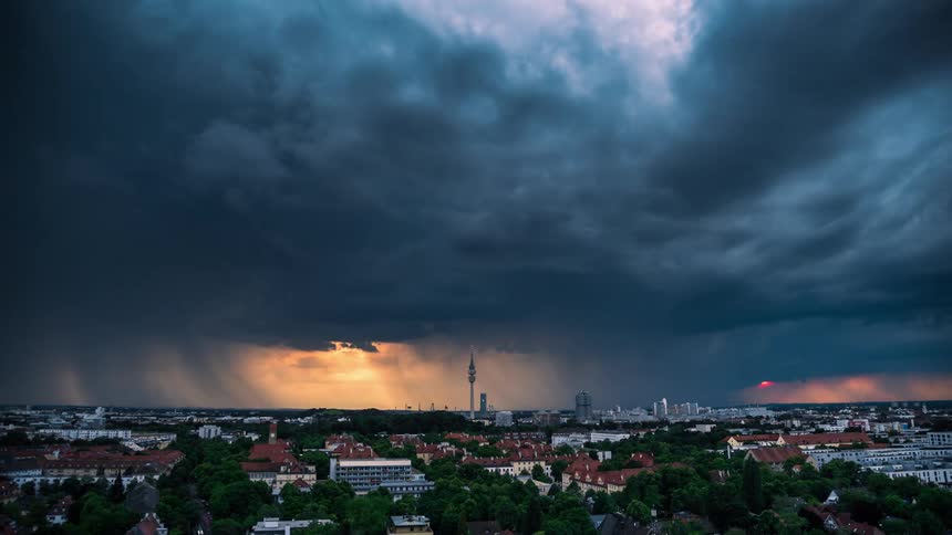 Panoramic view of a city at dusk with a dramatic sky where dense dark clouds