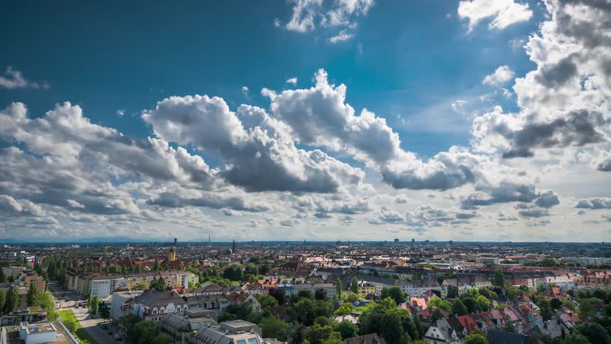 Clouds move over a city and suburb with lots of traffic on its streets