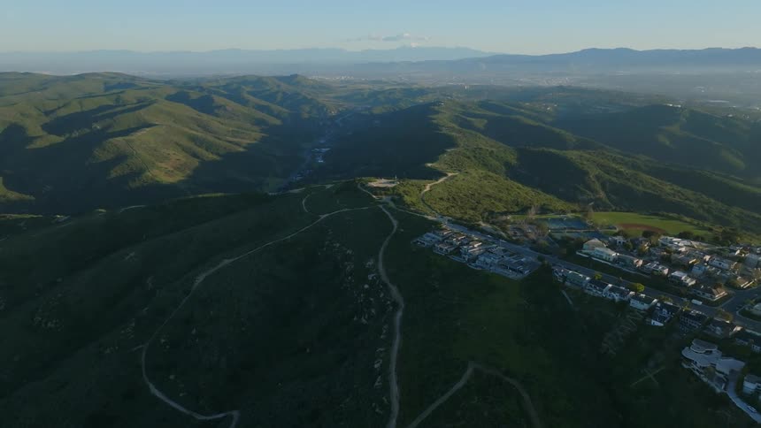 Panorama of a mountain valley with an urban city on the horizon