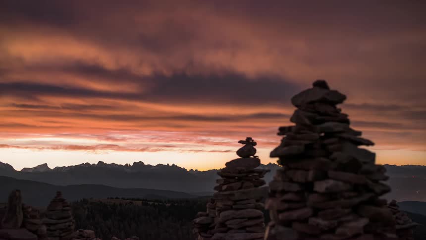 Stacks of rocks silhouetted against a sunsetcolored sky