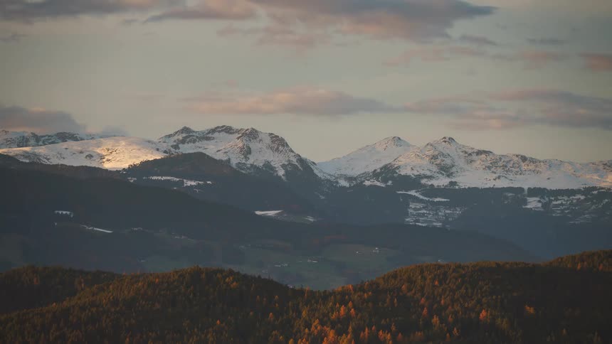 Mountainous landscape with snowcapped peaks against a cloudy sky