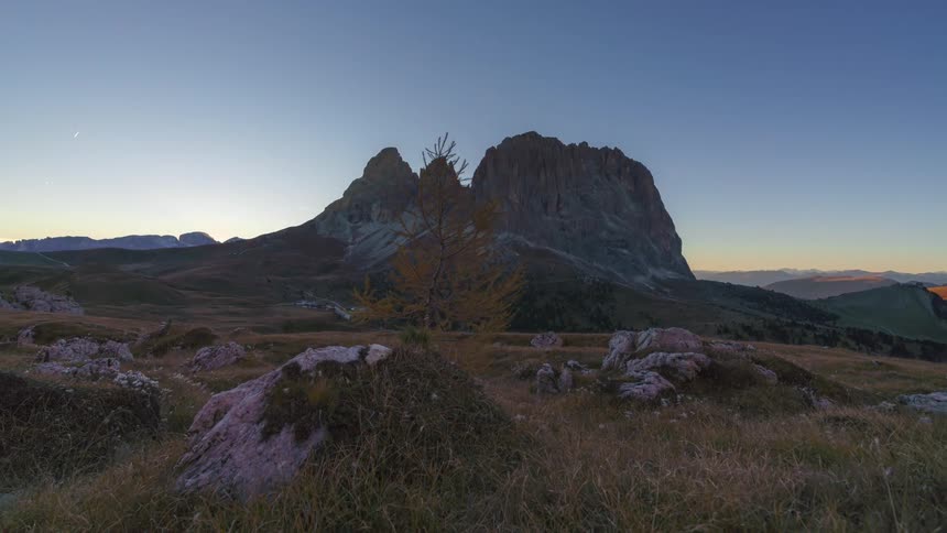 Landscape with rocky peak and the sun setting on the horizon