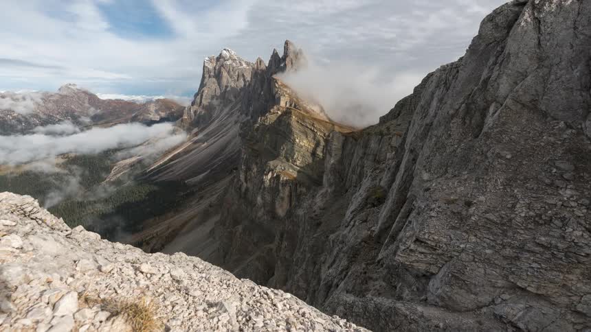Rocky mountain landscape with low fog on a day with partly cloudy sky