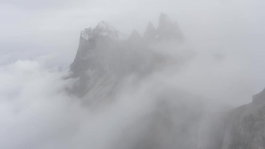 Dense overcast clouds passing over rocky mountains