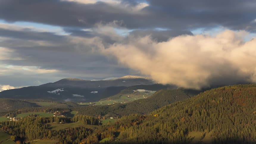 Storm clouds above mountains with vegetation and snow