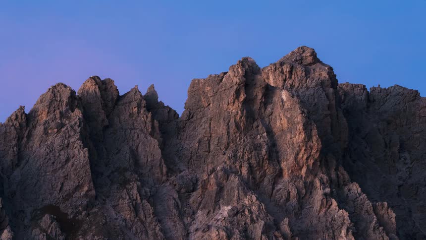A clear sky is above the mountains