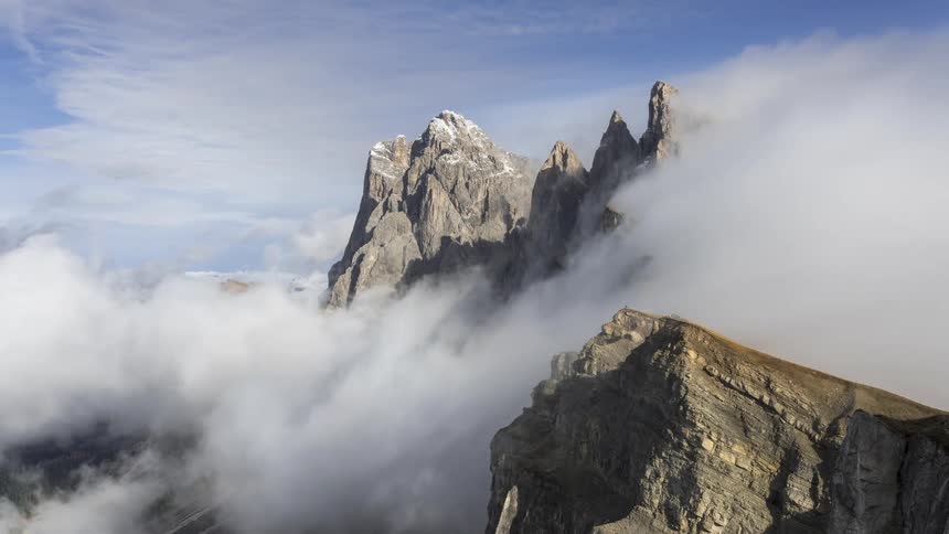 Obscured by wispy clouds the mountains peak reaches for the sky