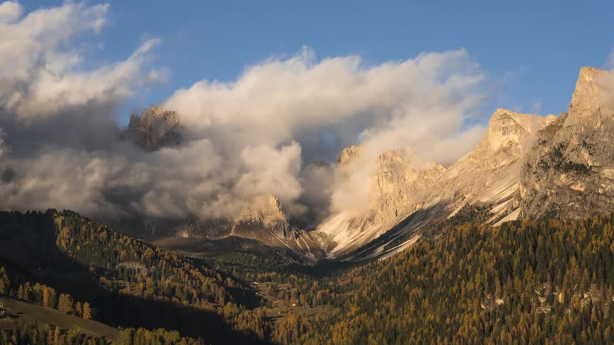 Time lapse of clouds rolling across the top of mountain peaks