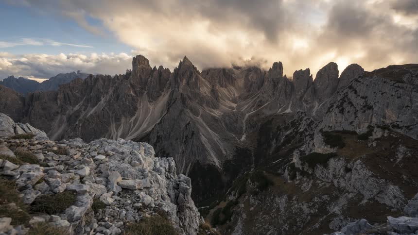 Panorama of mountains with moving cliffs and dense clouds