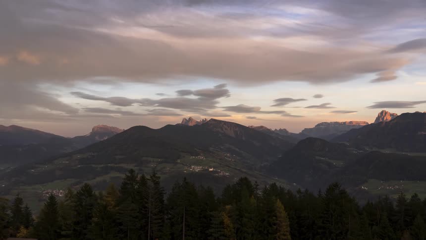 Mountainous landscape with conifers and a dusk sky