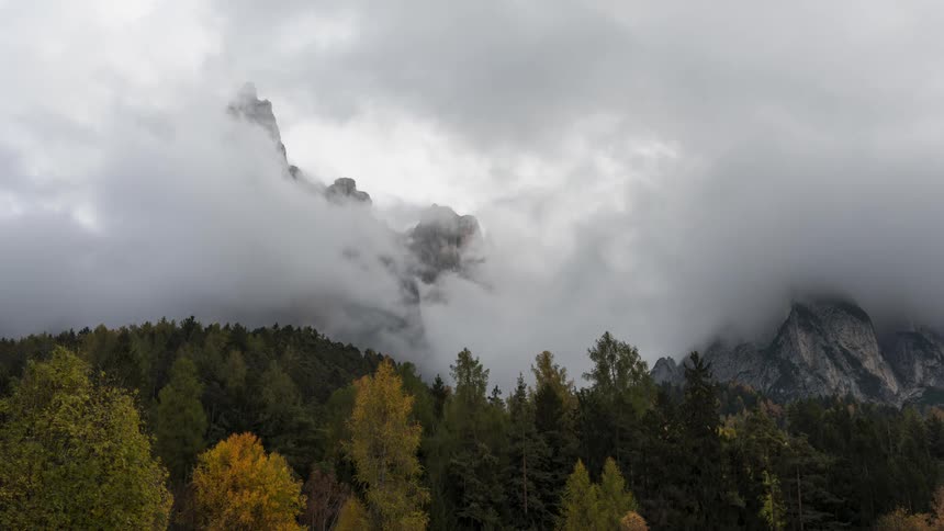 Mountainous landscape with forested mountains and dense clouds