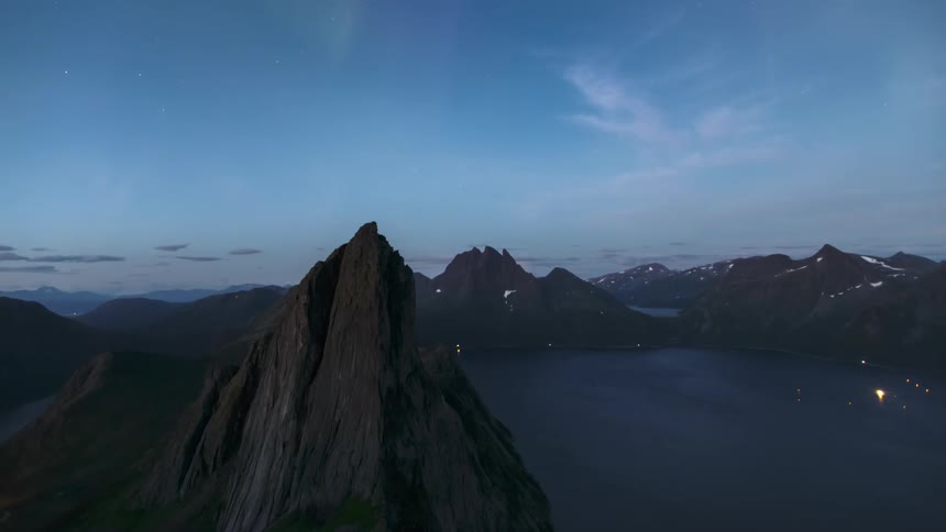 Scenery of mountains surrounded by the sea and the sky with the northern lights