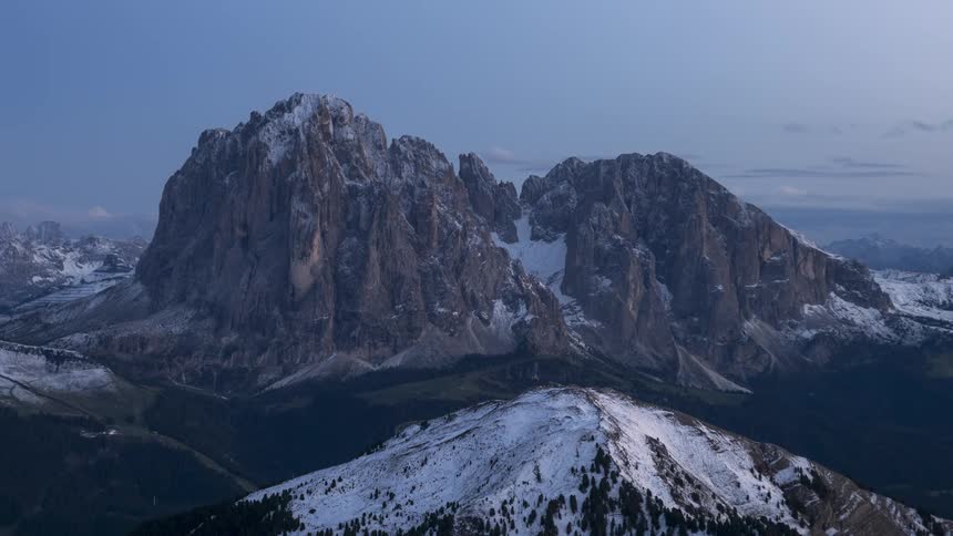 Mountainous landscape with snowcapped peaks and the darkening day