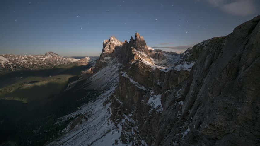 Landscape of snowy mountain cliffs with the day darkening and dawning