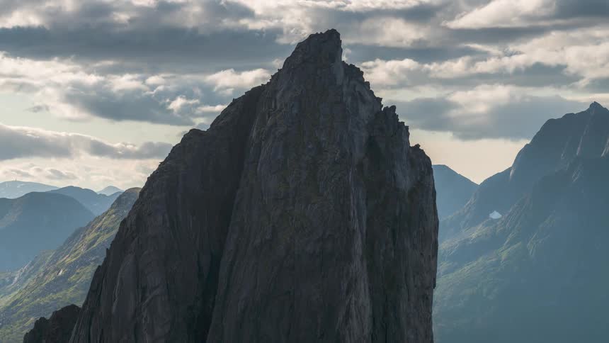 Mountain range with rocky peaks and cliffs against a cloudy sky