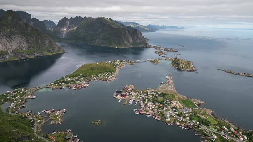 Aerial view of an archipelago highlighting a small coastal town surrounded by steep mountains and calm waters