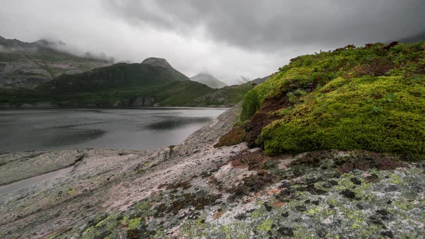 Rocky coast in mountains by a lake on a cloudy day
