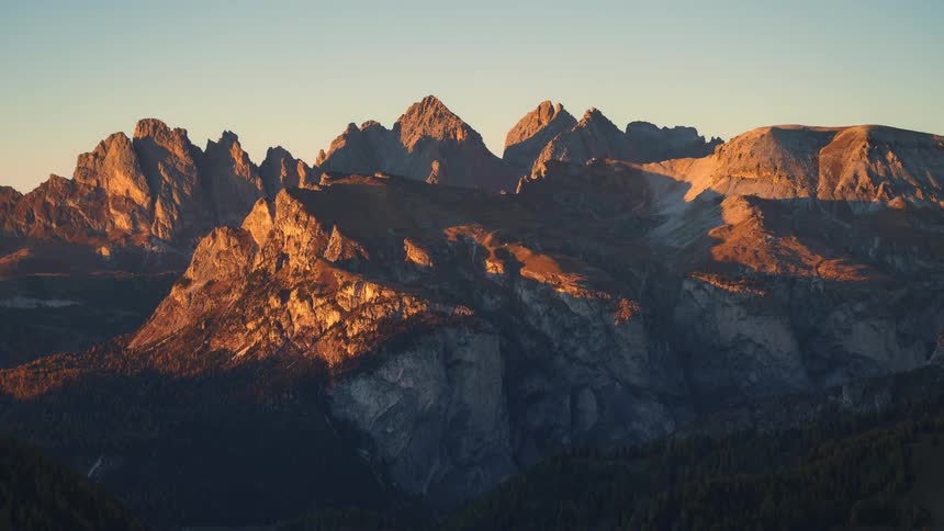 The last rays of the sun cast an orange glow on the peaks of the sass rigais mountain range