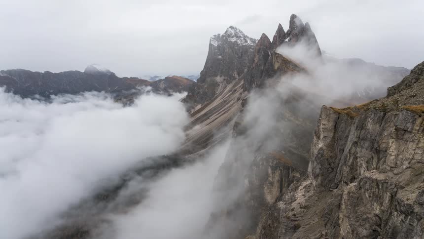 The clouds float just below the peak of the mountain