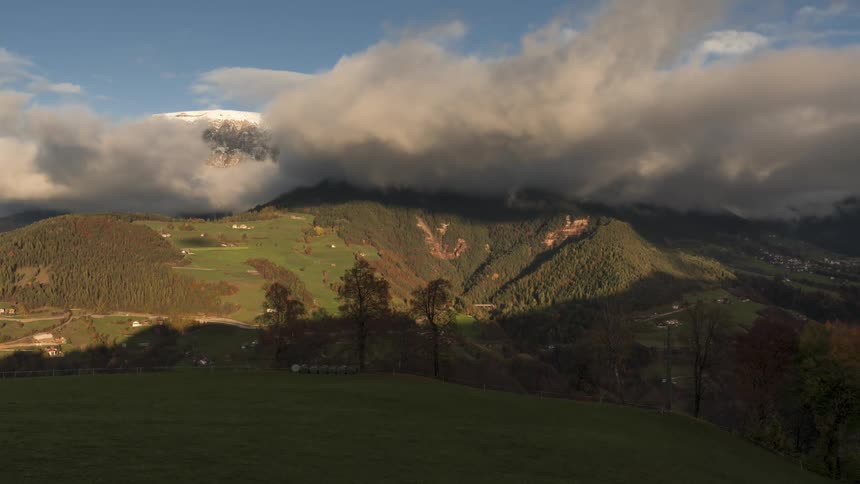 Time lapse of low clouds rolling over a mountainous landscape