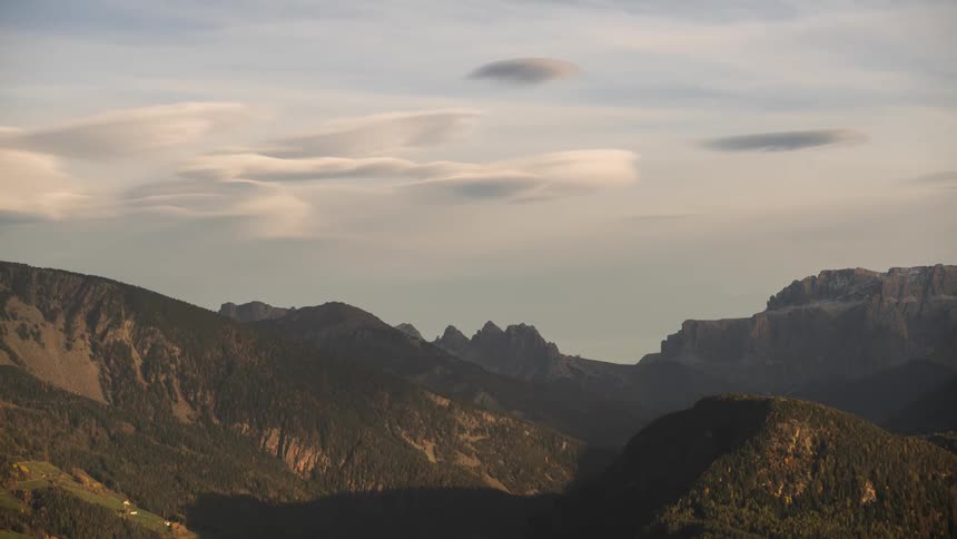 Landscape of rocky mountain ranges with shadows passing through the reflection of sunlight