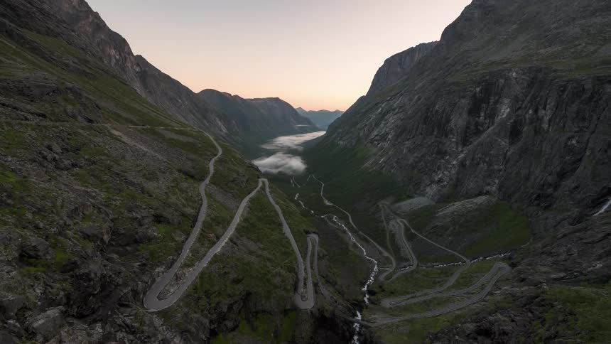 Landscape of winding road through the mountains on a dawning sky