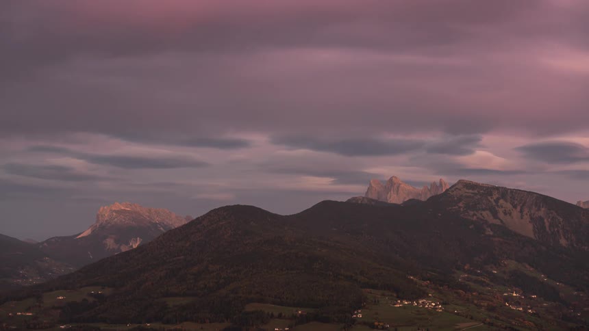 Dark clouds move across the sky over rural communities nestled in a mountain valley