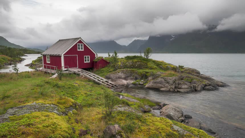 An enormous bank of clouds blows over a home on a coast
