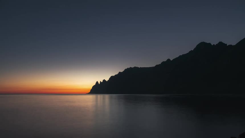 The sun is rising on the shore